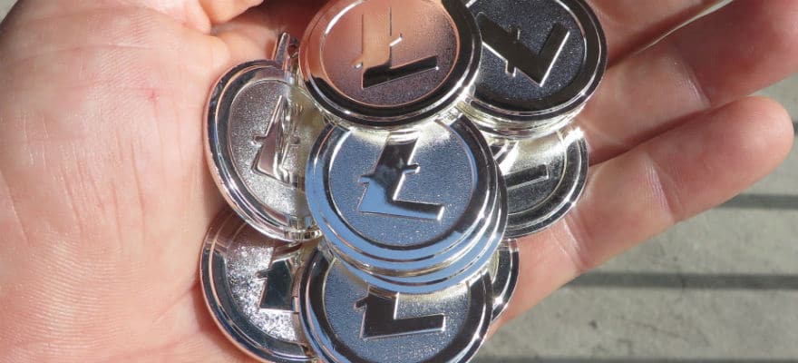 A hand holding physical litecoin