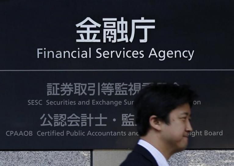 A man walks past a sign of Japan's Financial Services Agency (FSA) at its headquarters in Tokyo November 5, 2013. REUTERS/Toru Hanai